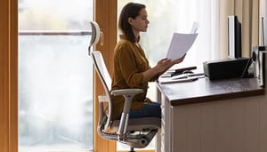 Female employee sitting at ergonomic home office desk